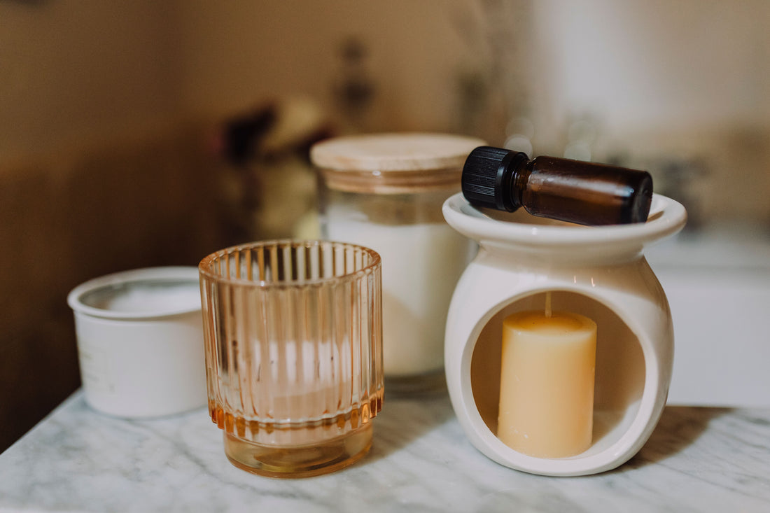 A wax melt burner beside candles - two ways to scent a room